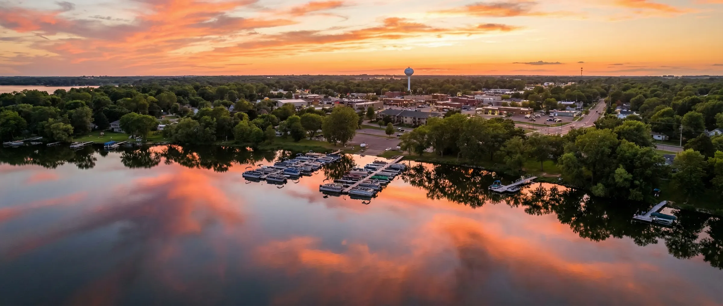 Aerial view of Lake Waconia Minnesota at golden hour sunset with marina and tree-lined shoreline